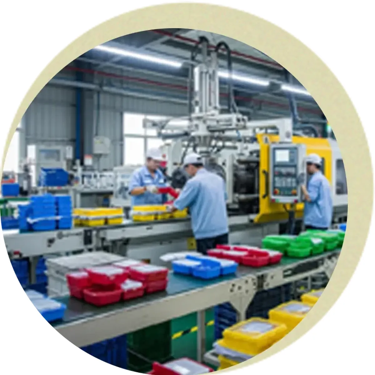 Blue, red, green and yellow moulded containers moving along a conveyor out of an injection moulding machine