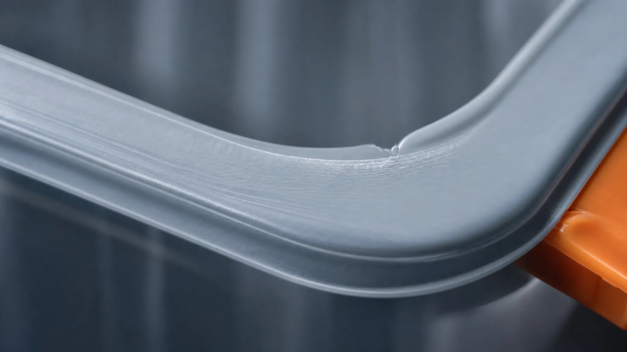An extreme close-up of a moulded container rim in raking light showing a small short-shot defect at one corner